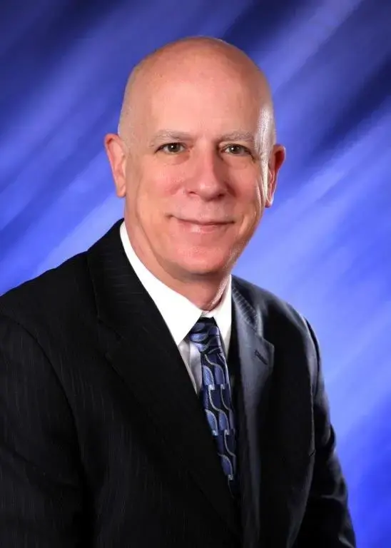 Dr. Donald Reno, smiling in a dark suit